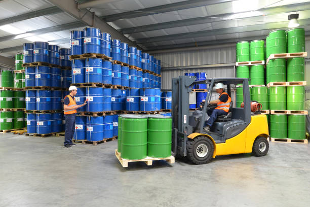 group of workers in the logistics industry work in a warehouse with chemicals - lifting truck