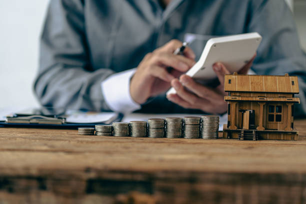 Check list before buying a new home to meet the bank criteria. Close-up shot of silver coin drop and house model Savings by adding your money to the real estate owner in a futuristic concept.