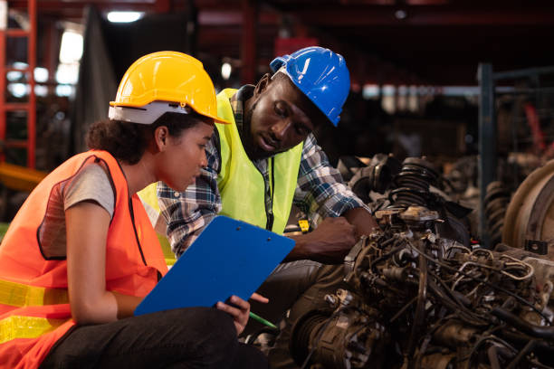 Black worker and engineer working and under inspection production process on factory.
