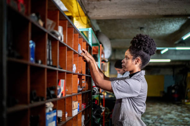 Auto mechanic woman organizing the shelf on a repair shop