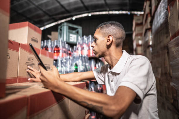 Young man working on digital tablet at a storage room