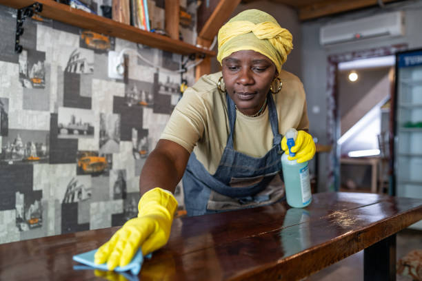 Afro female maid working at hostel disinfecting and preparing for the hostel guests after reopening