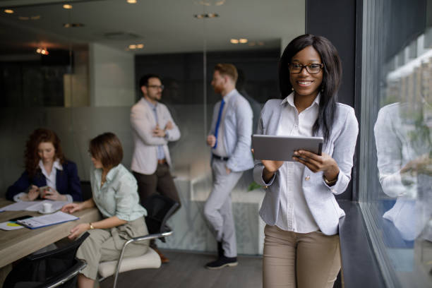 Portrait of young businesswoman in the office analyzing business report using digital tablet.