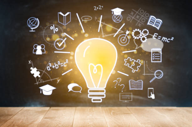 burning light bulb and digital holograms on the theme of education on the background of the chalkboard